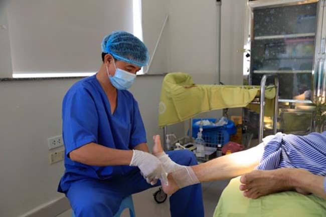 Bệnh nhân tiểu đường với biến chứng hoại tử chân đang được bác sĩ kiểm tra tại bệnh viện Nội tiết Trung Ương.